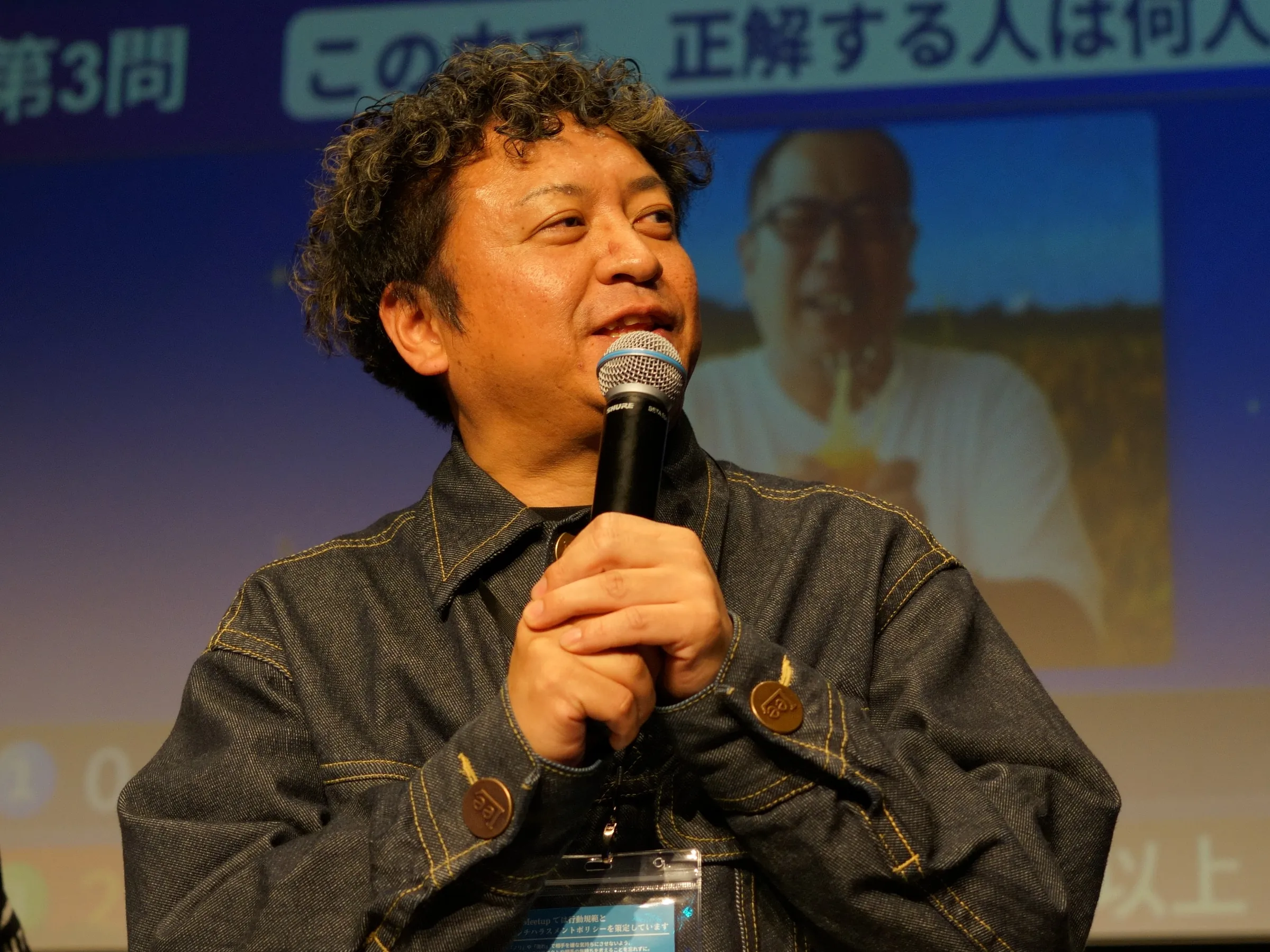 2026年2月20日、銀座で開いた年次総会で、マイクを両手で持って話す登壇者